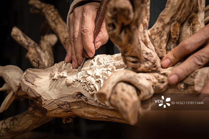 工匠师在树根上雕刻图片素材