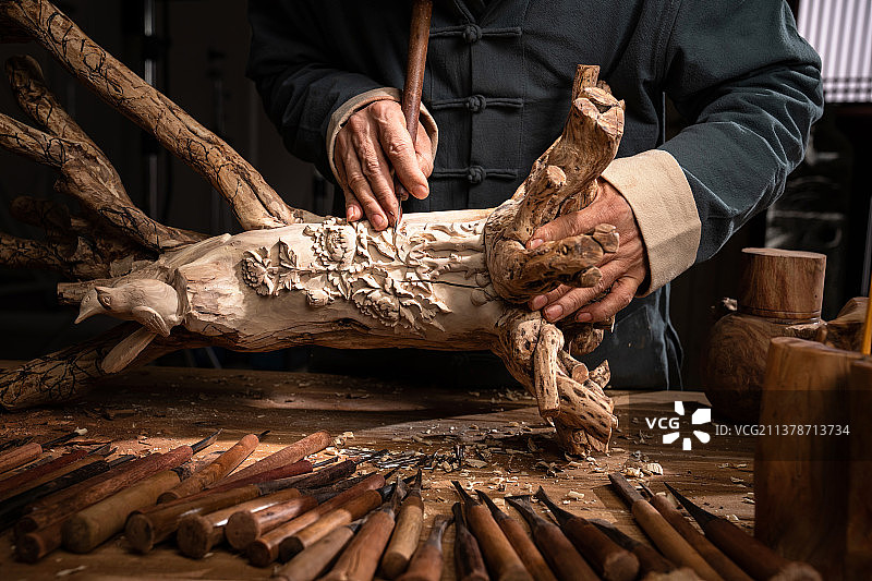 工匠师在树根上雕刻图片素材