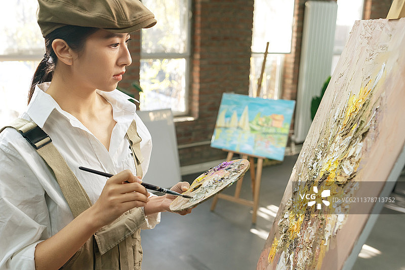 青年女画家在工作室里创作图片素材