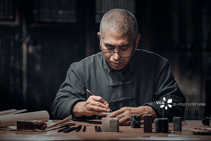 在工作室里认真雕刻印章的专家图片素材
