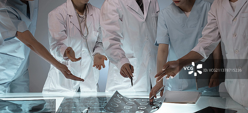 医务工作者用手指着X光片讨论研究图片素材