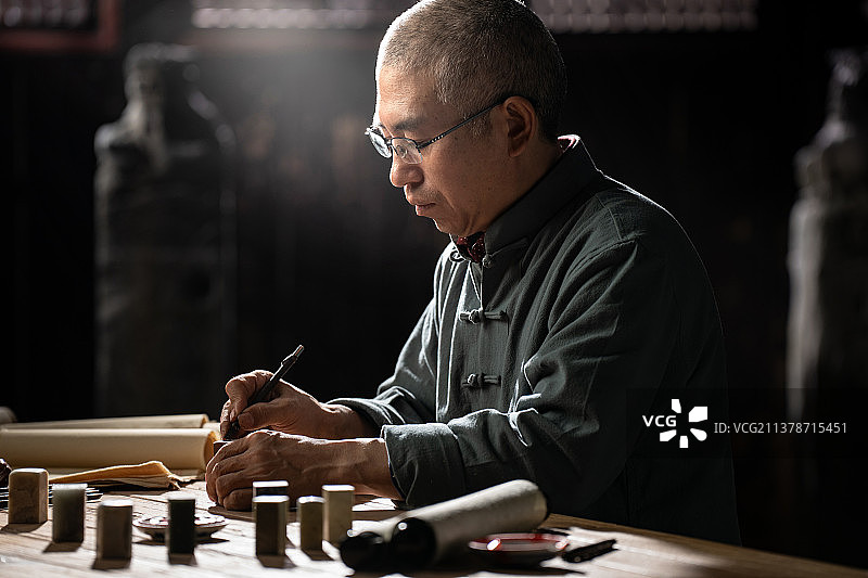 在工作室里认真雕刻印章的专家图片素材