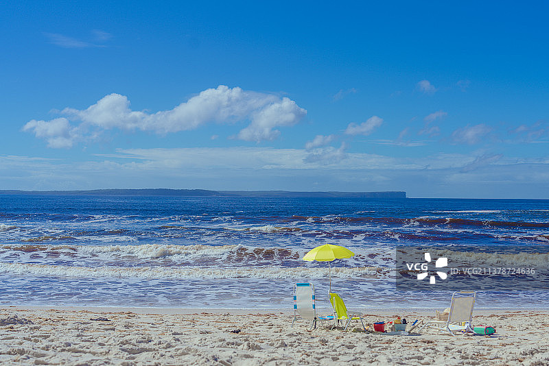 悉尼大白沙滩上的黄色遮阳伞与沙滩椅图片素材