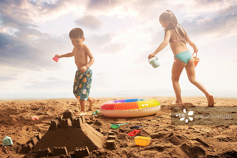 快乐的东方儿童在沙滩上玩耍图片素材