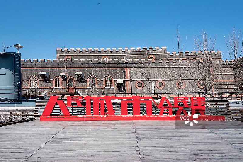 工业锈带变身生活秀带，蓝天白云下充满异国建筑风情的百年杨树浦水厂门口红色的人民城市人民建宣传口号图片素材