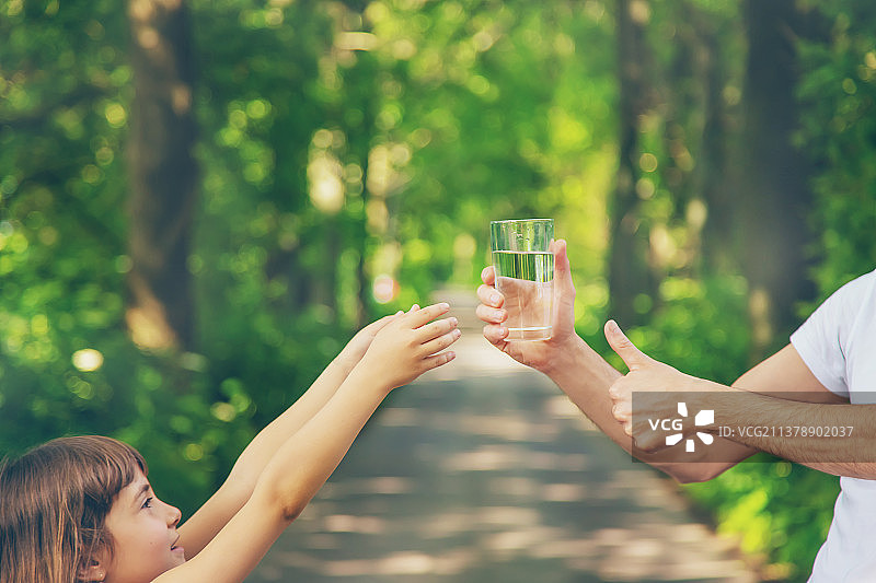 父亲给孩子一杯新鲜水（选择性聚焦）图片素材
