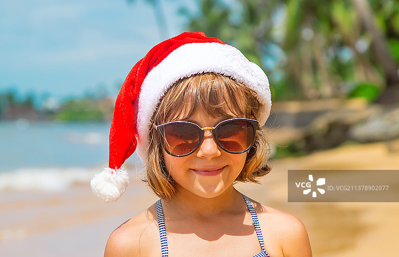 沙滩上，扮演圣诞老人的儿童图片素材