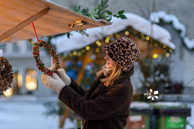 在塔林圣诞市场享受圣诞节的女人，爱沙尼亚塔林图片素材