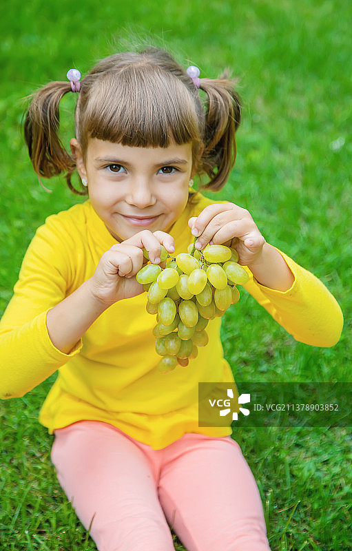 孩子吃白色葡萄，选择性聚焦图片素材