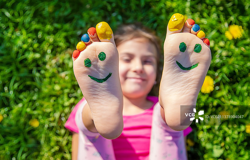 草地上的孩子脚画着微笑，选择性聚焦图片素材