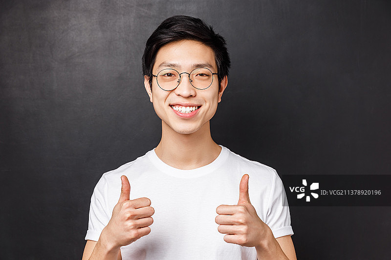 身穿白色T恤的自信亚洲青年男子特写图片素材