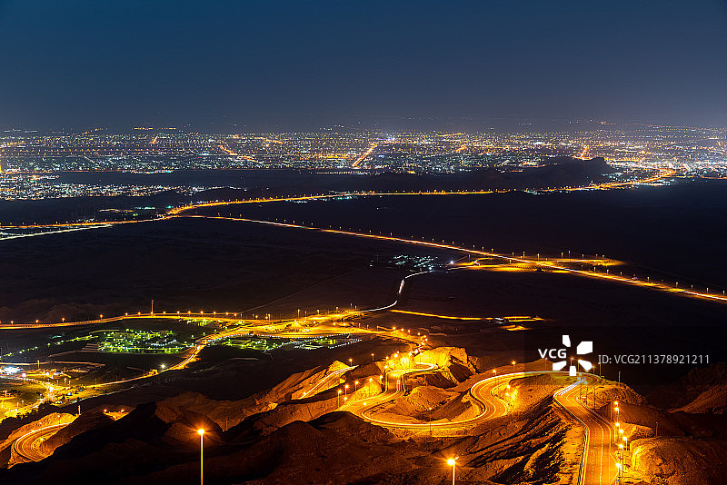 艾因的夜景城市景观：城市中灯火通明的建筑物高角度视图图片素材