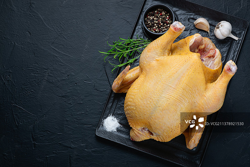 黑石板上配有香料的生鸡肉图片素材
