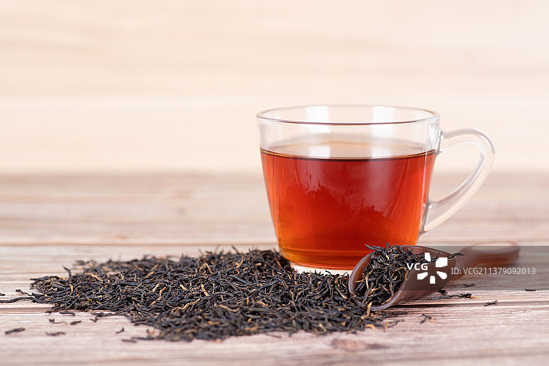 一杯红茶茶水和散落的茶叶图片素材