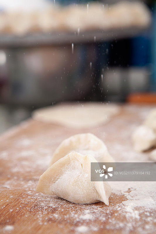 往包好的饺子上撒面粉图片素材