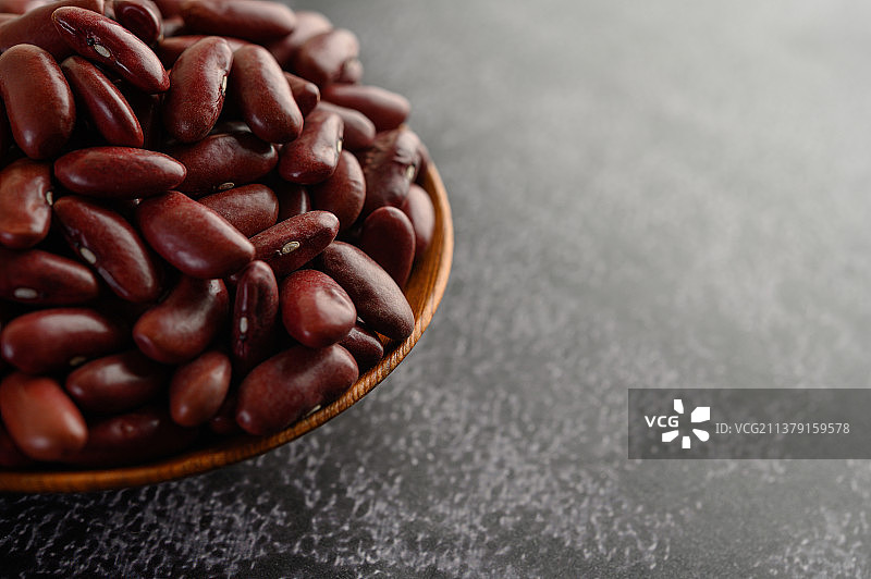 黑水泥地上木碗里的红豆图片素材