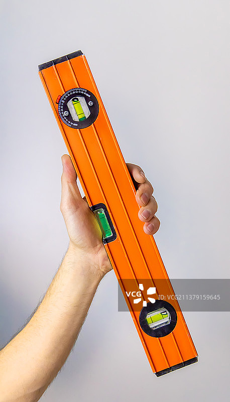 男性隔离者手中的水平仪特写图片素材