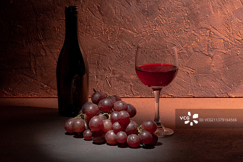 静物概念：一杯红酒和新鲜葡萄置于乡村背景之上图片素材