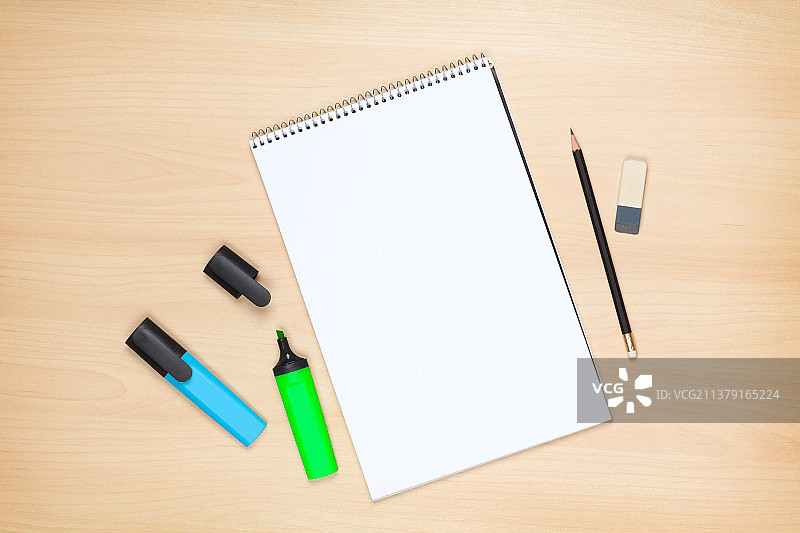 木桌上的空白记事本、荧光笔、铅笔和橡皮擦图片素材