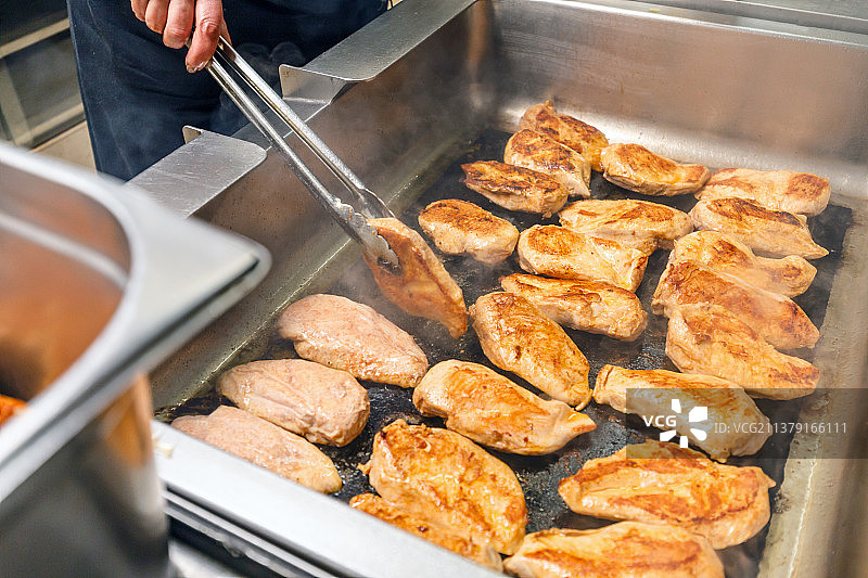 烤架上的鸡胸肉，厨师在厨房准备食物图片素材
