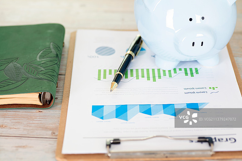 金融图表资料和笔记本及小猪存钱罐图片素材