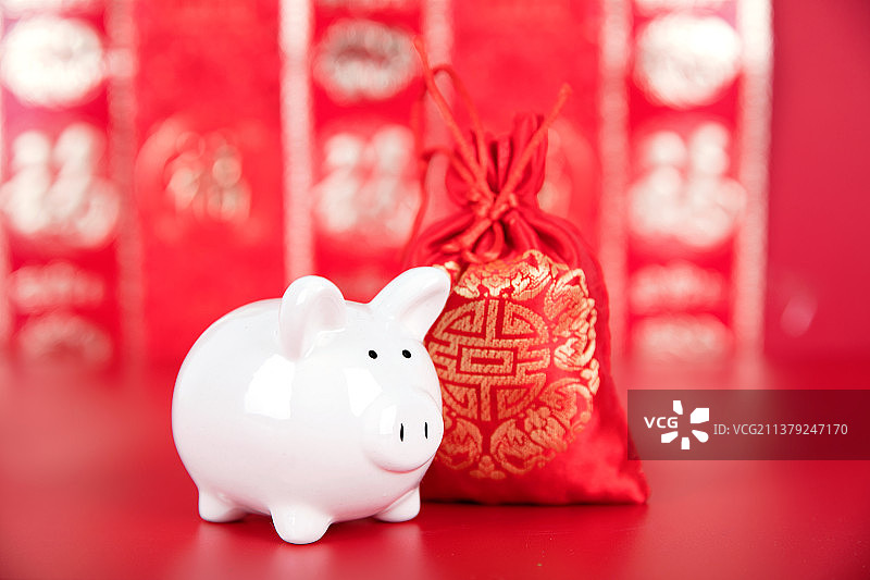 红色背景里的钱袋子和小猪存钱罐图片素材