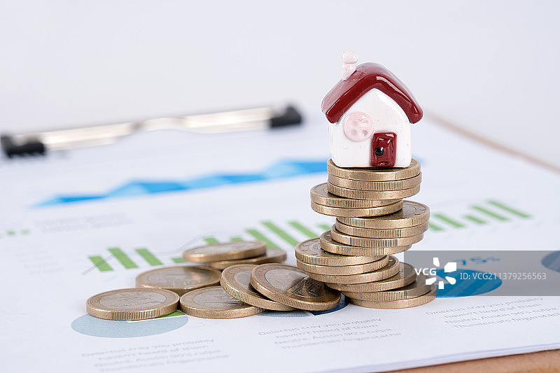 金融图表上的欧元硬币和小房子模型图片素材