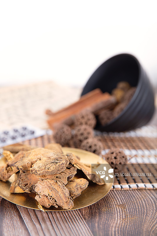 中药大黄和碗里散落的枫球子图片素材