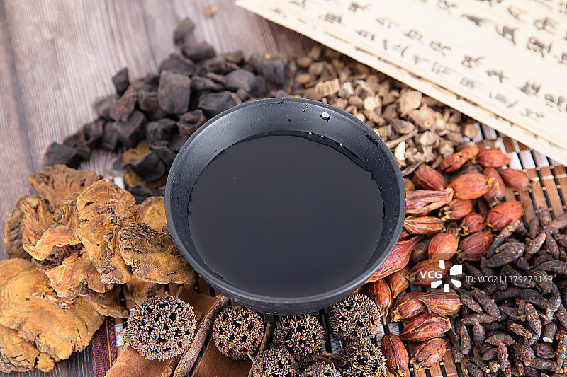 一堆各种各样的中药和药方及一碗煎好的汤药图片素材