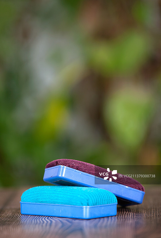 竖构图虚化绿背景前的黑板擦图片素材