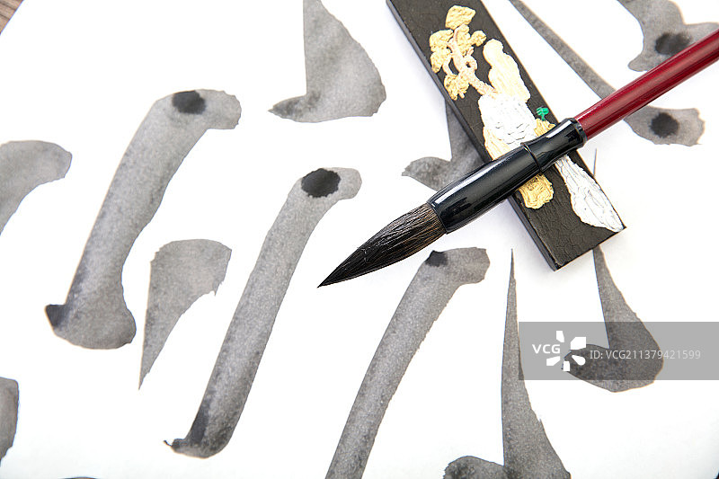 白纸上的毛笔笔触和一杆毛笔及一个墨条图片素材