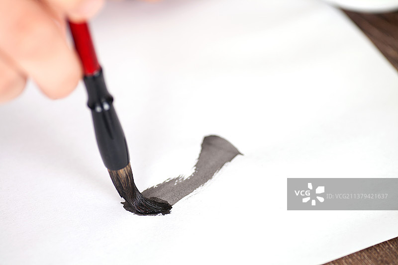 毛笔在白纸上书写的特写图片素材