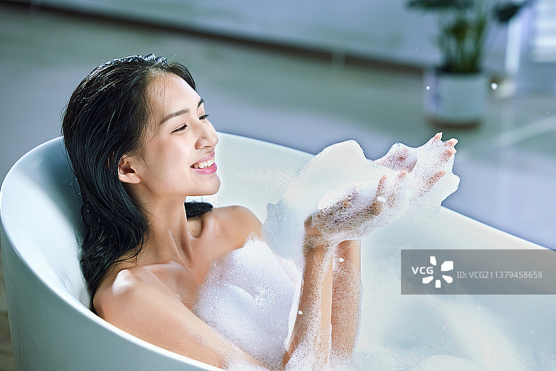 漂亮的年轻女人洗泡泡浴图片素材