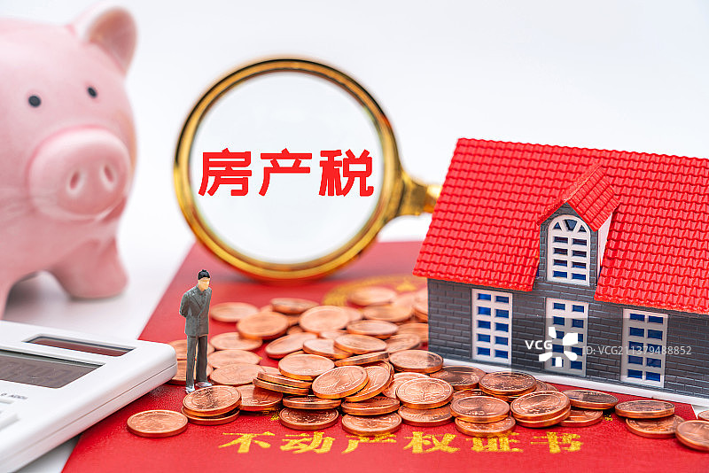 透过放大镜观察房地产热点概念——房产税图片素材
