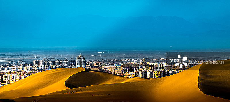 与城市相连的库木塔格沙漠图片素材