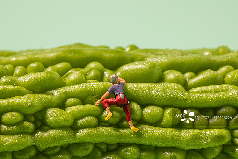 创意摄影在苦瓜上攀岩的小人图片素材