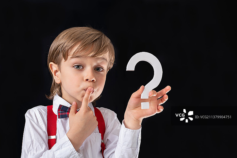 拿着问号标志的可爱学龄前男童图片素材
