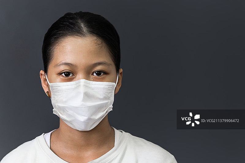 戴着防护口罩哭泣的亚洲年轻女孩，泰国图片素材