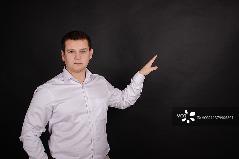 黑色背景上穿白衬衫的英俊男子肖像图片素材
