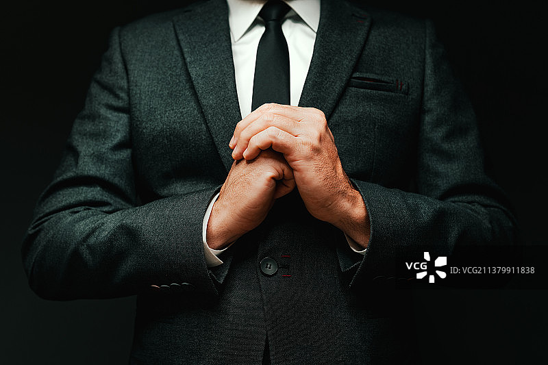 站在黑色背景前的商务人士身体中部特写，塞尔维亚图片素材