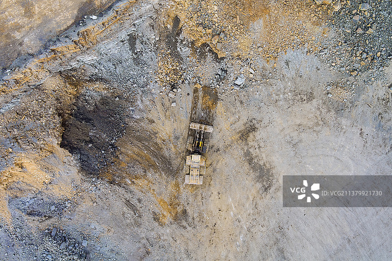 挖掘机将采矿岩石装入自卸卡车，用于石材破碎机图片素材