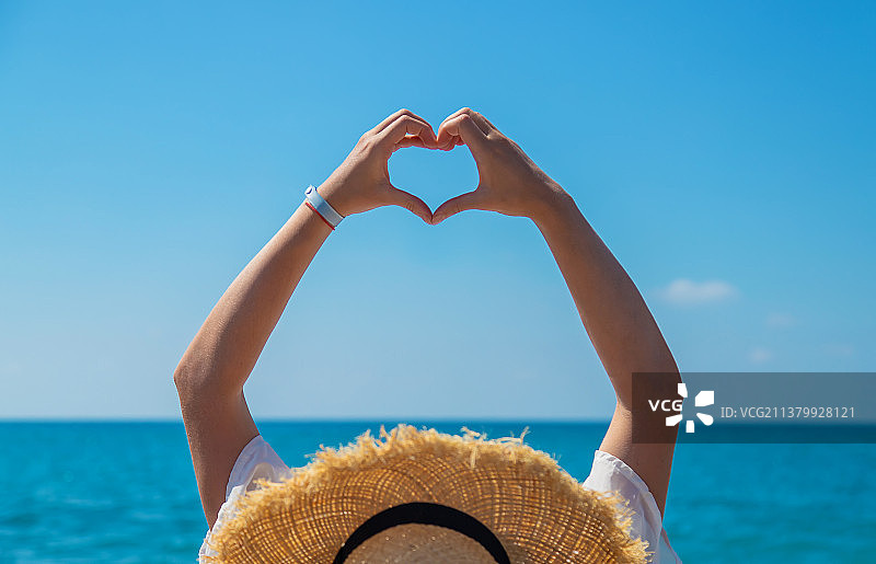 戴帽子的女人在海滩上（选择性焦点）图片素材