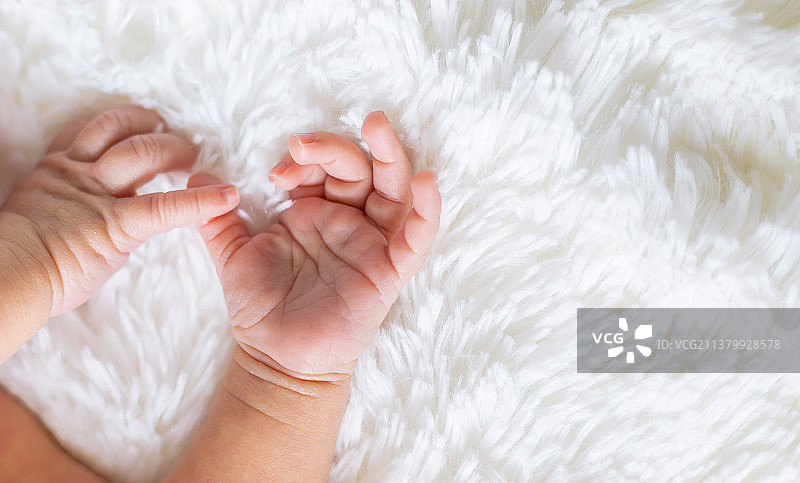 新生幼儿在白色背景上的手部特写图片素材