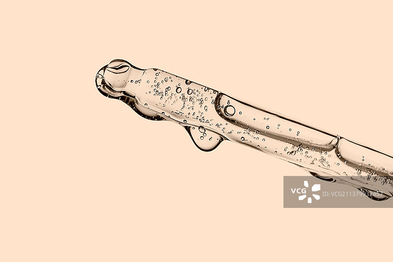 米色背景上的化妆品透明滴管图片素材