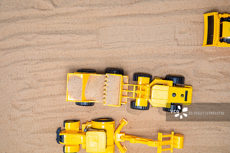 沙地上的玩具拖拉机：建设与规划概念图片素材