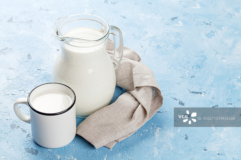 桌上玻璃罐和马克杯中牛奶的高角度视图图片素材