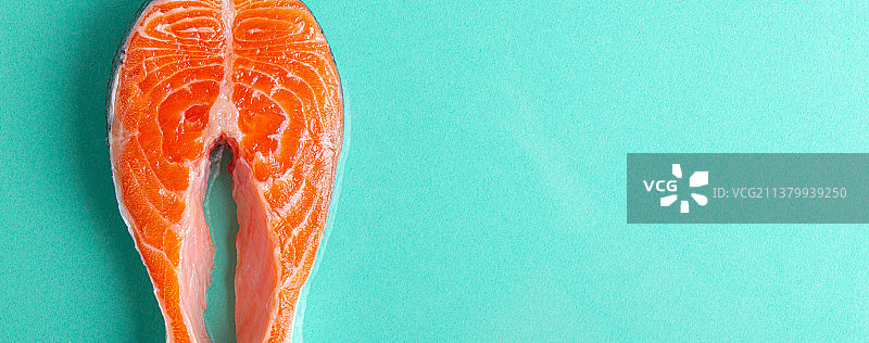 蓝色背景上的未煮熟生鲜三文鱼牛排图片素材