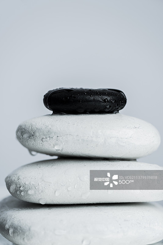 黑白禅意特写：白色背景下的堆叠鹅卵石图片素材