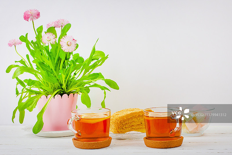 两杯红茶、棉花糖、蛋糕片和粉色花盆图片素材