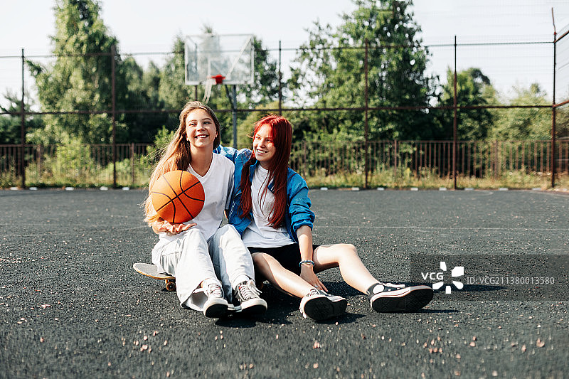 两个女孩在篮球场上赛后放松图片素材